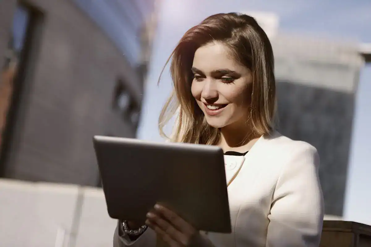 A woman in a business suit is using a tablet.