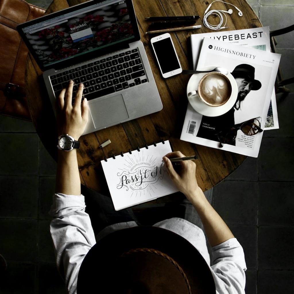 Top view of a creative workspace with laptop, coffee, and hand lettering for design inspiration. What Is a Marketing Service? A Deep Dive Into the Digital Strategies That Actually Grow Your Business